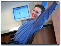 Man seated in desk chair stretching 